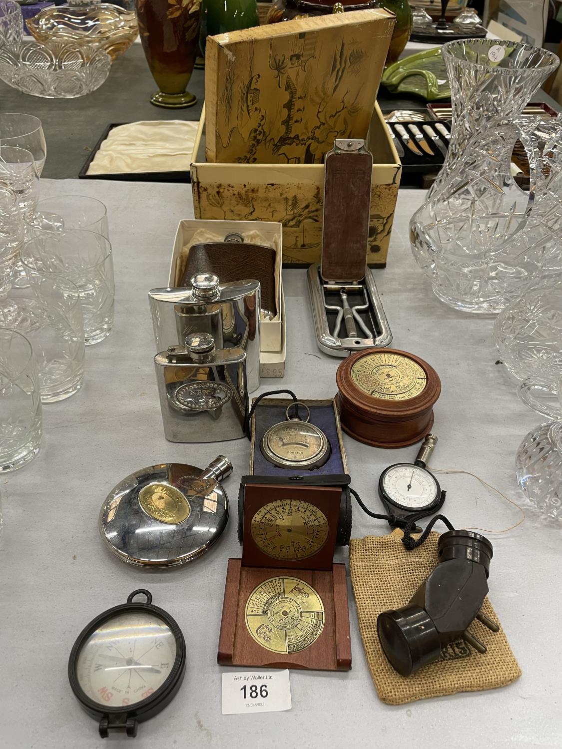 A VINTAGE TIN CONTAINING HIP FLASKS, COMPASSES, ROLLS RAZOR, ETC