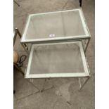 A NEST OF TWO METAL FRAMED GLASS TOP TABLES