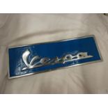 A CHROME AND BLUE VESPA SIGN, 43CM X 14CM