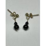 A PAIR OF 9 CARAT GOLD EARRINGS WITH A BLACK POSSIBLY JET DOUBLE BEAD DROP IN A PRESENTATION BOX