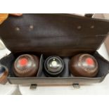 A SET OF BOWLING BOWLS IN A CASE