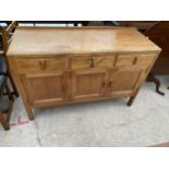 AN OAK SIDEBOARD BY HEAL'S OF LONDON, ENCLOSING THREE DRAWERS AND THREE CUPBOARDS, 54" WIDE