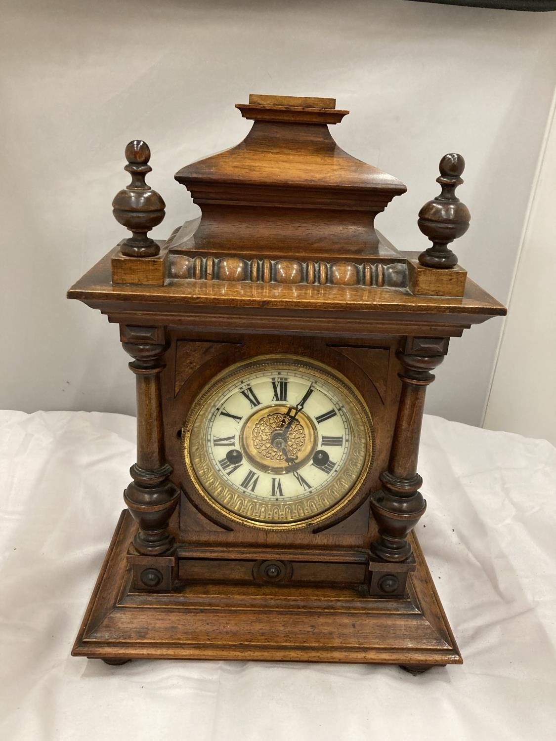 A MAHOGANY CASED MANTLE CLOCK WITH COLUMN DECORATION AND ROMAN NUMERALS HEIGHT 38CM, WIDTH 26CM,