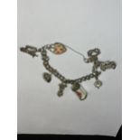 A SILVER CHARM BRACELET WITH SEVEN CHARMS AND A HEART PADLOCK