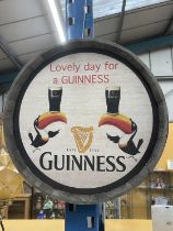 A WOODEN BARREL TOP LOVELY DAY FOR A GUINESS SIGN