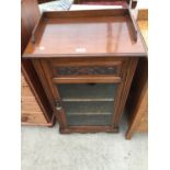 A VICTORIAN MAHOGANY GALLERY TOP MUSIC CABINET WITH GLASS DOOR BEARING MUSIC CARVING
