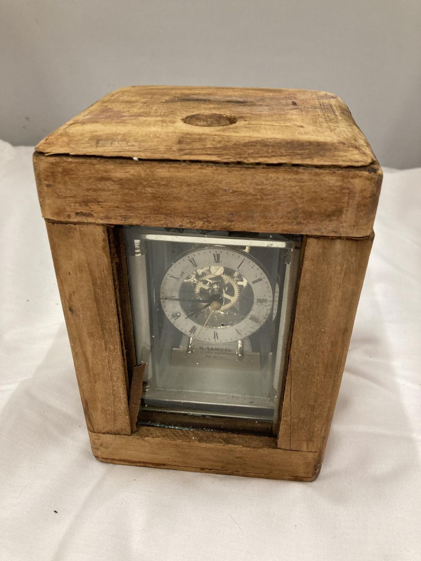 A CARRIAGE CLOCK IN A WOODEN CASE