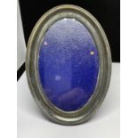 A WHITE METAL OVAL PHOTOGRAPH FRAME
