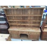 A VICTORIAN PINE KITCHEN DRESSER WITH THREE DRAWERS AND TWO CUPBOARDS TO THE BASE, COMPLETE WITH