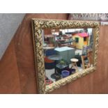 A DECORATIVE GILT FRAMED WALL MIRROR