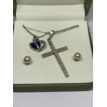 TWO SILVER NECKLACES TO INCLUDE A CROSS PENDANT AND A BLUE AND CLEAR STONE HEART TWIST AND A PAIR OF