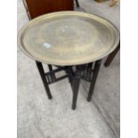 AN INDIAN BRASS TOP TABLE, 23" DIAMETER, ON FOLDING AND TURNED BASE