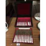 A SET OF MOTHER OF PEARL HANDLED KNIVES AND FORKS IN A MAHOGANY BRASS INLAID BOX