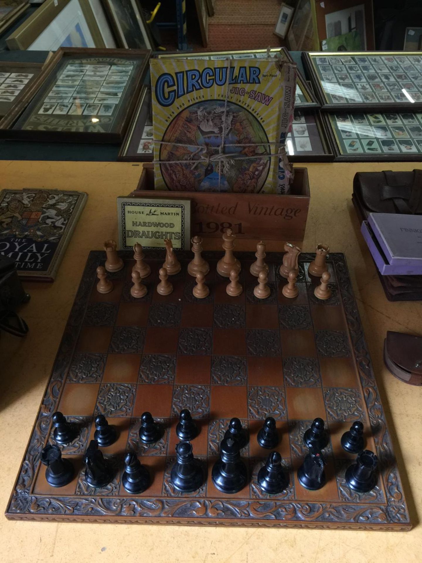 A WOODEN CARVED CHESSBOARD COMPLETE WITH THE PIECES PLUS DRAUGHTS AND A VINTAGE JIGSAW