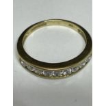 A 9 CARAT GOLD RING WITH NINE IN LINE CUBIC ZIRCONIA SIZE O/P