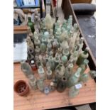 A LARGE QUANTITY OF VINTAGE GLASS BOTTLES SOME BEARING NAMES