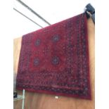 A LARGE RED PATTERNED RUG