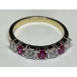 A 9 CARAT GOLD RING WITH THREE RUBYS AND FOUR DIAMONDS ALL IN LINE K/L