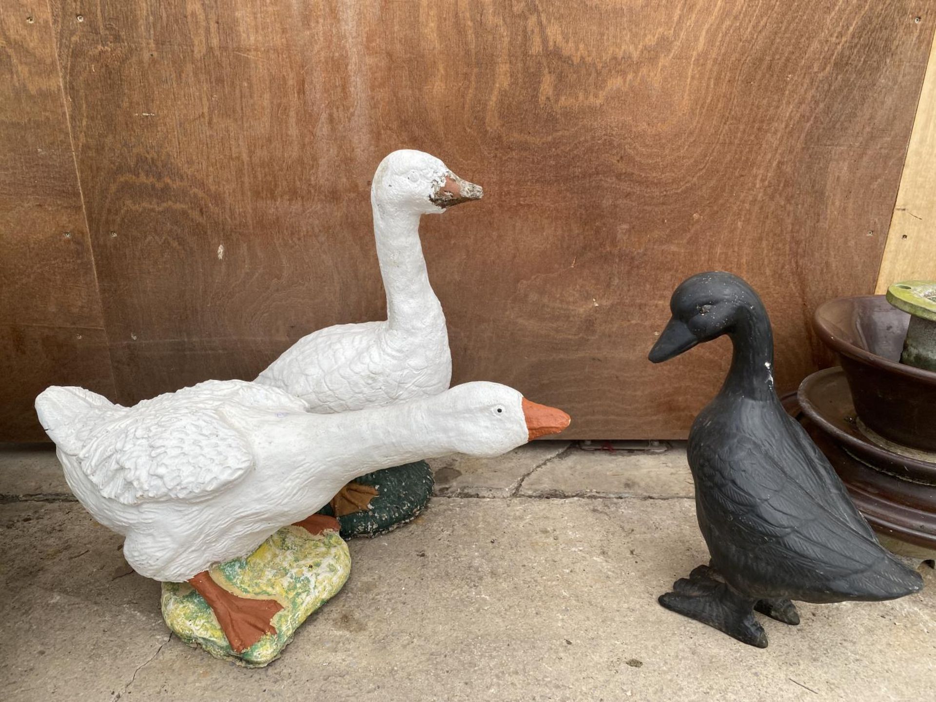 A PAIR OF RECONSTITUTED STONE GEESE AND A POT DUCK