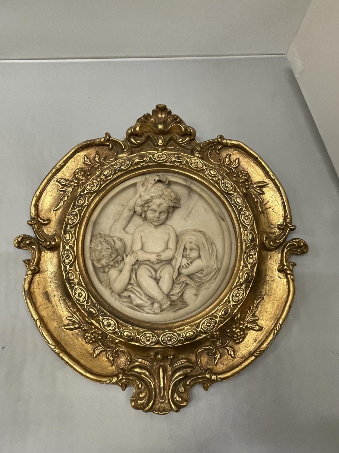 AN ORNATE GILT FRAMED PLAQUE OF CHILDREN DIAMETER 33CM