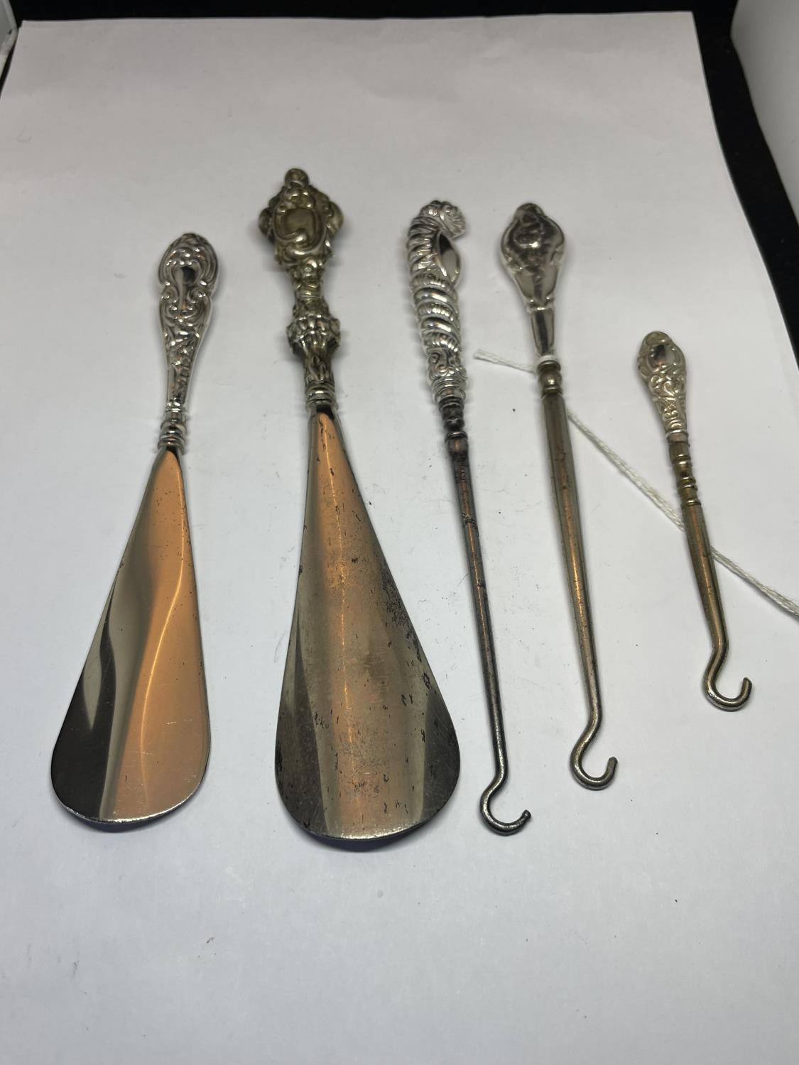 FIVE SILVER HANDLED ITEMS TO INCLUDE BUTTON HOOKS AND SHOE HORNS