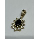 A 9 CARAT GOLD PENDANT WITH A POSSIBLY SAPPHIRE CENTRAL STONE SURROUNDED BY CLEAR STONES GROSS