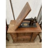 A SINGER TREADLE SEWING MACHINE IN CARVED CABINET ENCLOSING DRAWERS WITH APPLIED CARVINGS