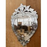 A DECORATIVE BEVELED EDGE WALL MIRROR WITH FLORAL ETCHING