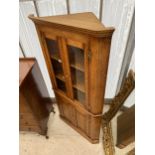 A GEORGE III STYLE OAK CORNER CUPBOARD WITH GLAZED UPPER PORTION AND CUPBOARDS TO THE BASE, WITH H-