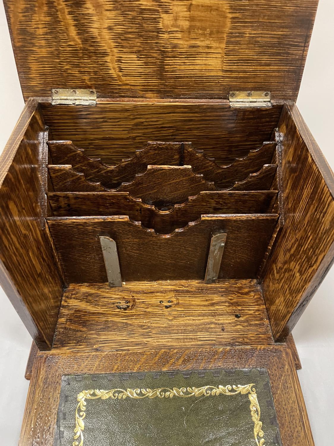 AN EARLY 20TH CENTURY OAK STATIONARY BOX WHICH OPENS TO A LEATHER WRITING DESK, SHIELD ON THE LID. - Image 5 of 6