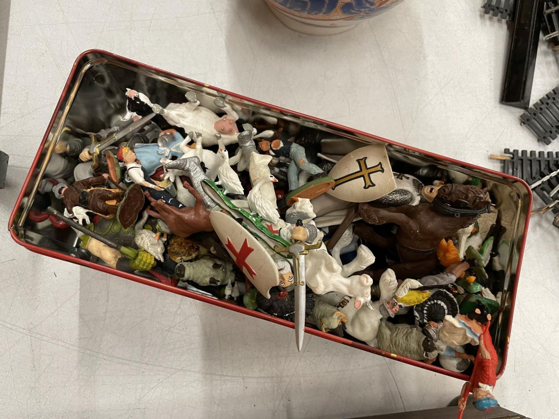 A TIN CONTAINING TOY ANIMALS AND SOLDIERS