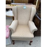 A WINGED PARKER KNOLL FIRESIDE CHAIR, NUMBER M.P.K.1-40, ON CABRIOLE LEGS