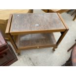 A TEAK AND CREAMY WLANUT EFFECT FOLD-OVER TROLLEY/TABLE ON BALL AND CLAW FEET