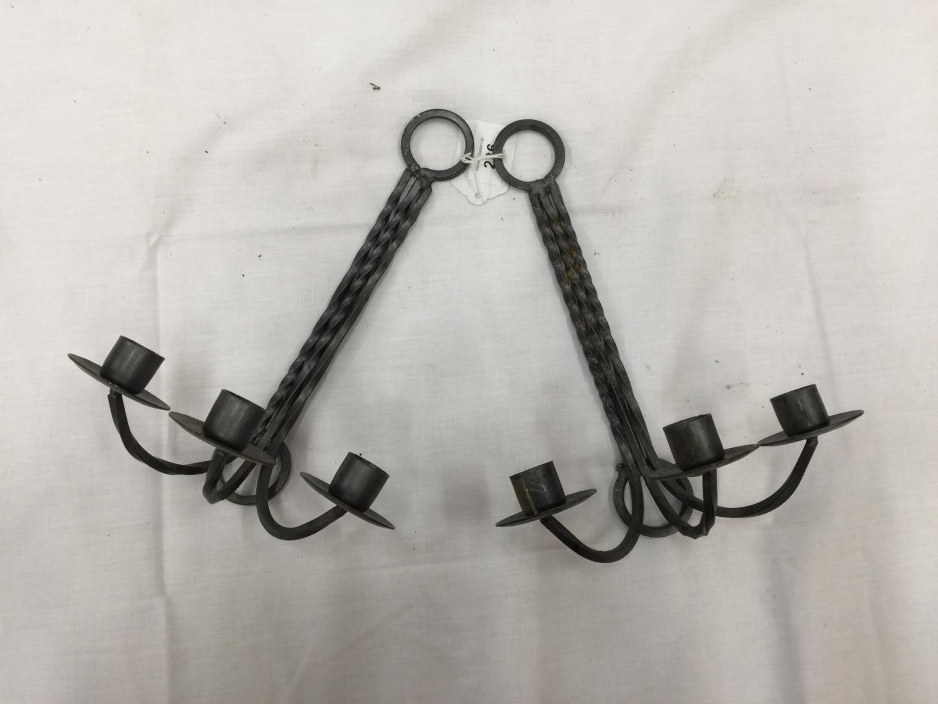 A PAIR OF WALL MOUNTED METAL CANDLESTICKS