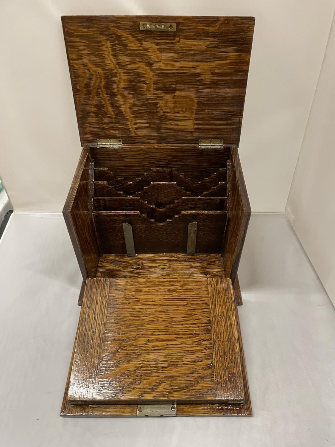 AN EARLY 20TH CENTURY OAK STATIONARY BOX WHICH OPENS TO A LEATHER WRITING DESK, SHIELD ON THE LID. - Image 3 of 6