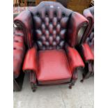 AN OXBLOOD WINGED FIRESIDE CHAIR ON CABRIOLE LEGS