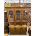 A MODERN GLAZED BOOKCASE ON BASE ENCLOSING THREE CUPBOARDS, 52" WIDE