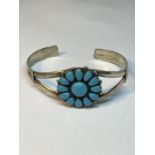 A MARKED SILVER BANGLE WITH TURQUOISE STONES IN A FLOWER DESIGN