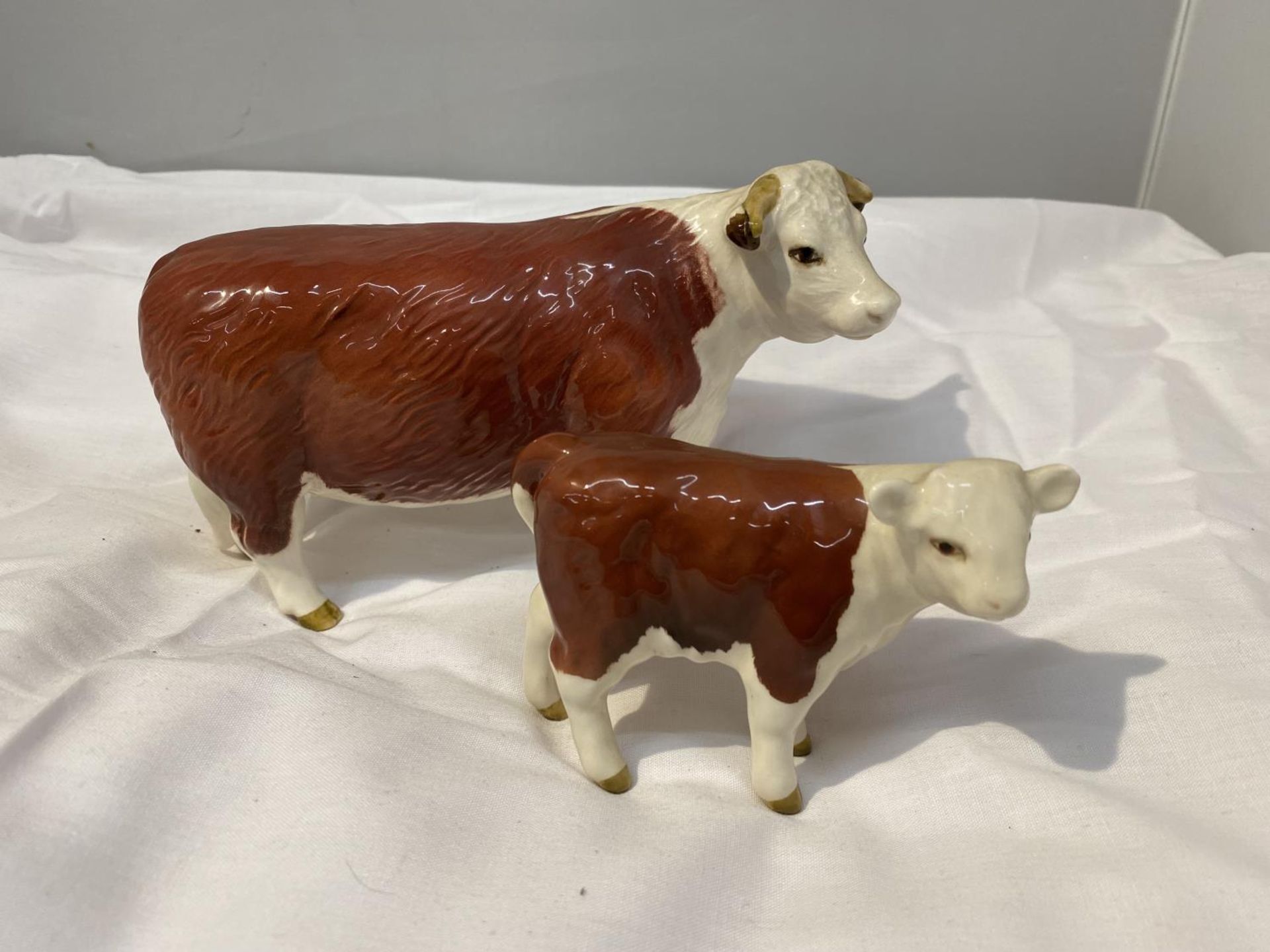 TWO BESWICK FIGURES, A HEREFORD COW AND A CALF