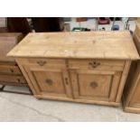A VICTORIAN PINE SIDEBOARD WITH TWO DRAWERS AND TWO CUPBOARDS WITH RAISED MOTIFS, 54" WIDE