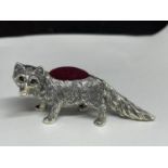 A SILVER MINIATURE PIN CUSHION IN THE FORM OF A FOX WITH RED STONE EYES