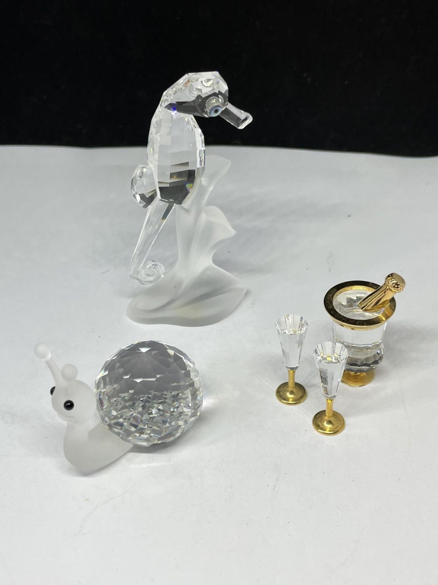 THREE SWAROVSKI CRYSTALS TO INCLUDE A SEAHORSE, SNAIL AND CHAMPAGNE BUCKET WITH BOTTLE AND FLUTES