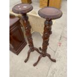 A PAIR OF VICTORIAN STYLE MAHOGANY TORCHERES ON TRIPOD BASES WITH FRUIT AND LEAF COLUMN DECORATION