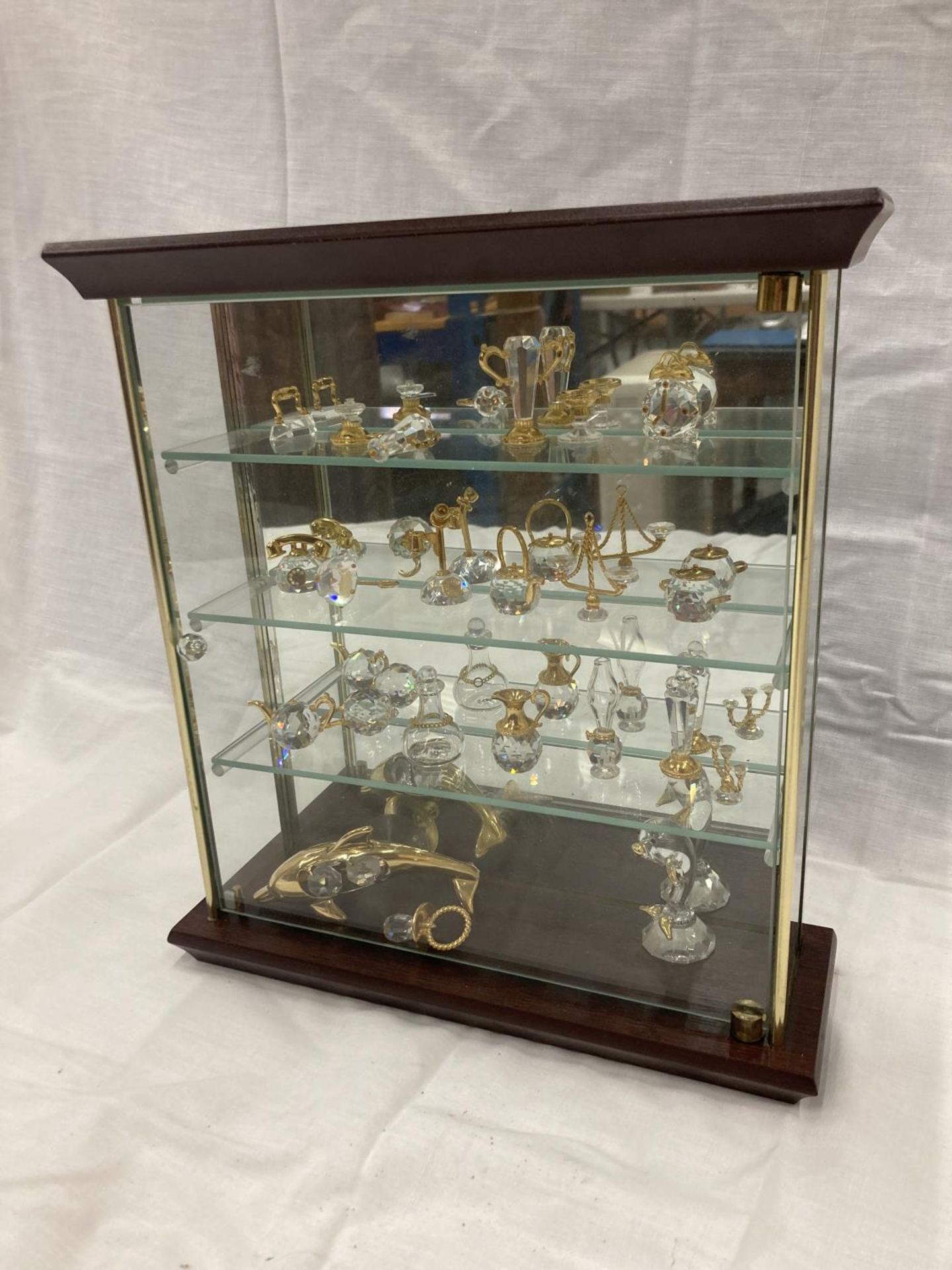 TWENTY PIECES OF SWAROSKI CRYSTAL IN A GLASS DISPLAY CASE