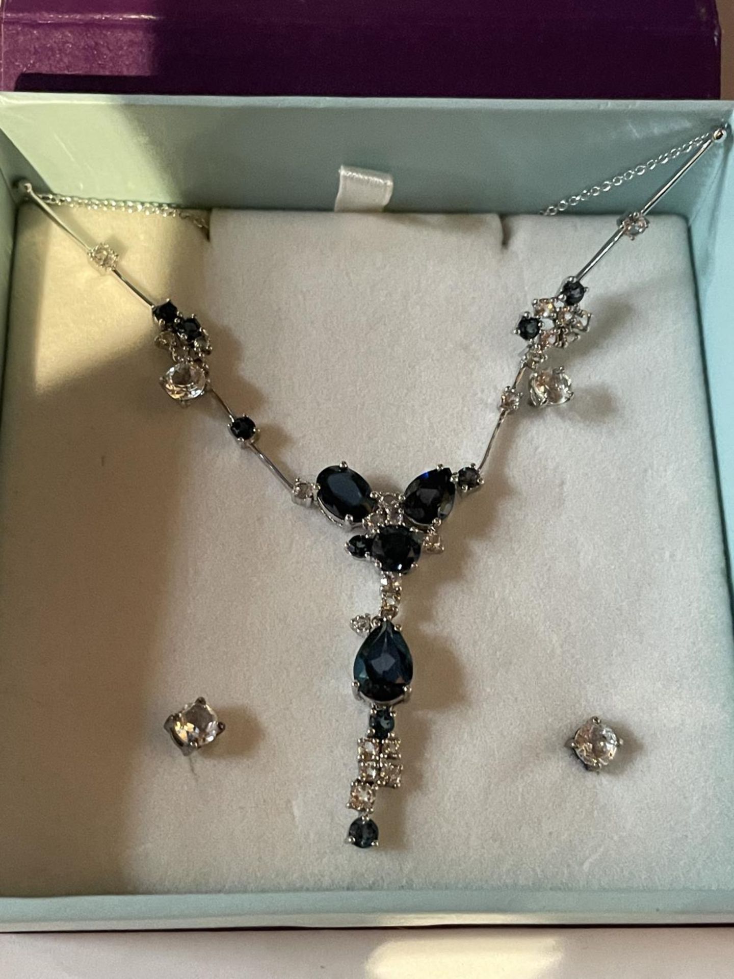 A BOXED MARKED SILVER BLUE STONE NECKLACE WITH BLUE AND CLEAR STONES AND FOUR CLEAR STONE STUD