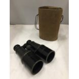 A PAIR OF BRASS PAINTED MILITARY BINOCULARS MARKED 1957 IN A CANVAS CASE