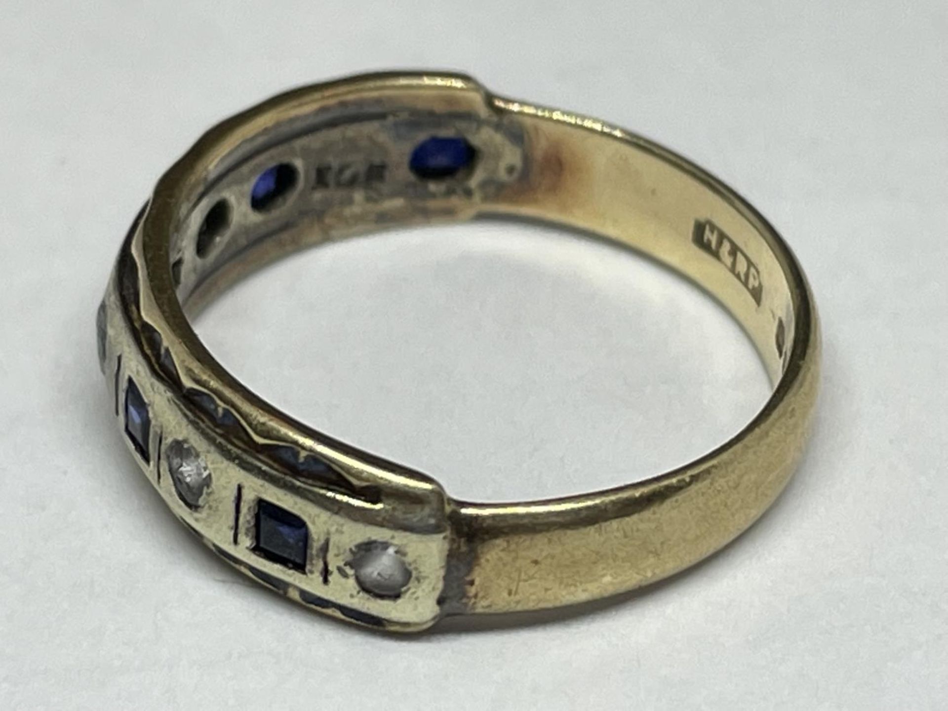 A 9 CARAT GOLD RING WITH FIVE SQUARE SAPPHIRES AND FIVE CLEAR STONES IN A BAND SIZE K - Image 2 of 4