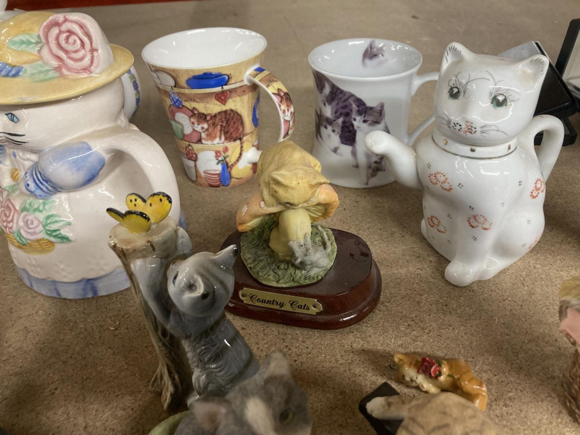 A COLLECTION OF RESIN AND POTTERY CAT RELATED ITEMS TO INCLUDE TEAPOTS, ORNAMENTS, DOORSTOP, MUGS, - Image 5 of 7