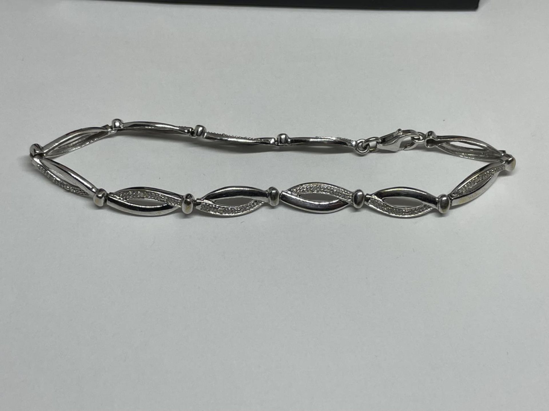 A 9 CARAT WHITE GOLD AND DIAMOND BRACELET IN A PRESENTATION BOX