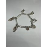 A MARKED SILVER CHARM BRACELET WITH SIX CHARMS TO INCLUDE A SHOE, FLIPFLOP, CORSET, TOP HAT,